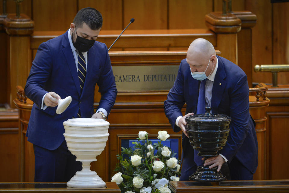 Parliament staff set up the urns before a parliament vote on Romanian Prime Minister designate Nicolae Ciuca and his government team in Bucharest, Romania, Thursday, Nov. 25, 2021. Romanian lawmakers voted in favor of a new coalition government led by a Liberal former army general, which could usher in an end to a months-long political crisis in the Eastern European nation.(AP Photo/Alexandru Dobre)