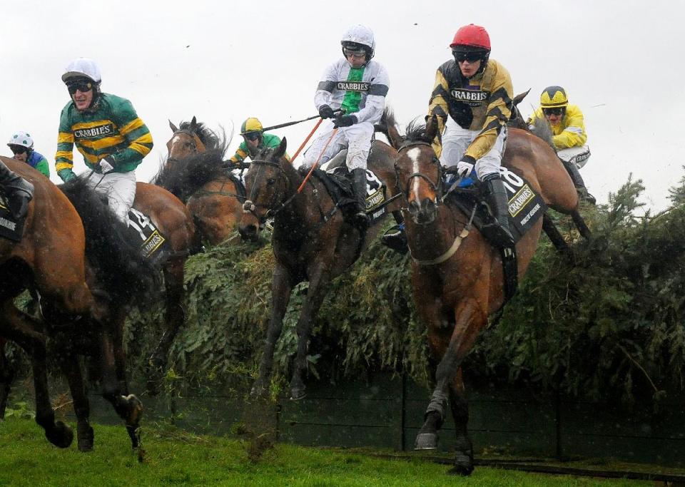 Pineau De Re, centre, ridden by Leighton Aspell, contends for the lead during the Crabbie's Grand National Steeple Chase event at Aintree Racecourse, Liverpool, England, Saturday April 5, 2014. Pineau De Re went on to win the race. Some 40 runners are competing in the 167th running of the world's most famous horse race at Aintree, with about 250 million pounds (414 million dlrs US) expected to be waged on the outcome of the four-and-a-half mile race over 30 fences. (AP Photo / Tim Ireland, PA) UNITED KINGDOM OUT - NO SALES - NO ARCHIVES