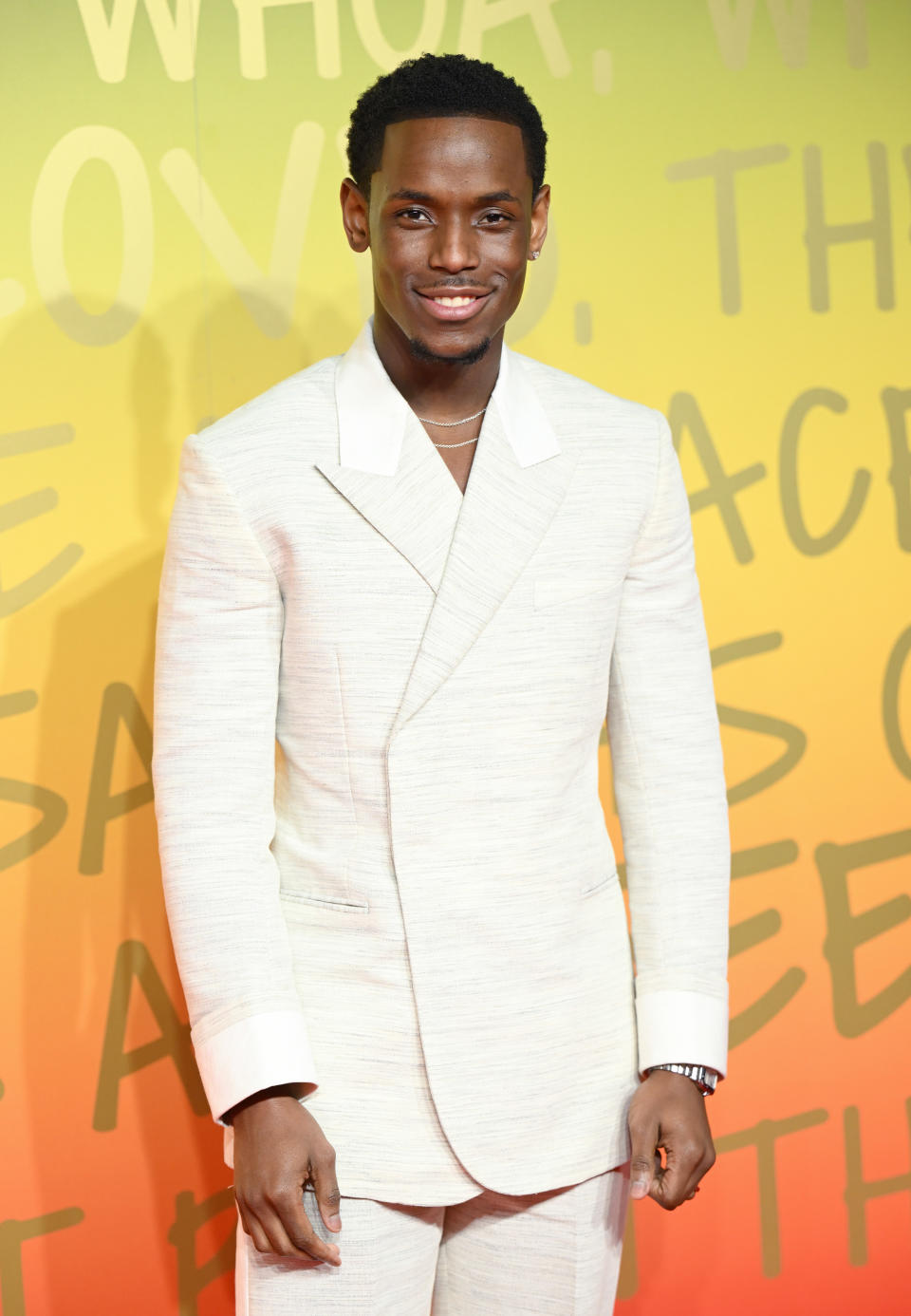 Michael Ward in a light-colored textured suit as he poses on the red carpet