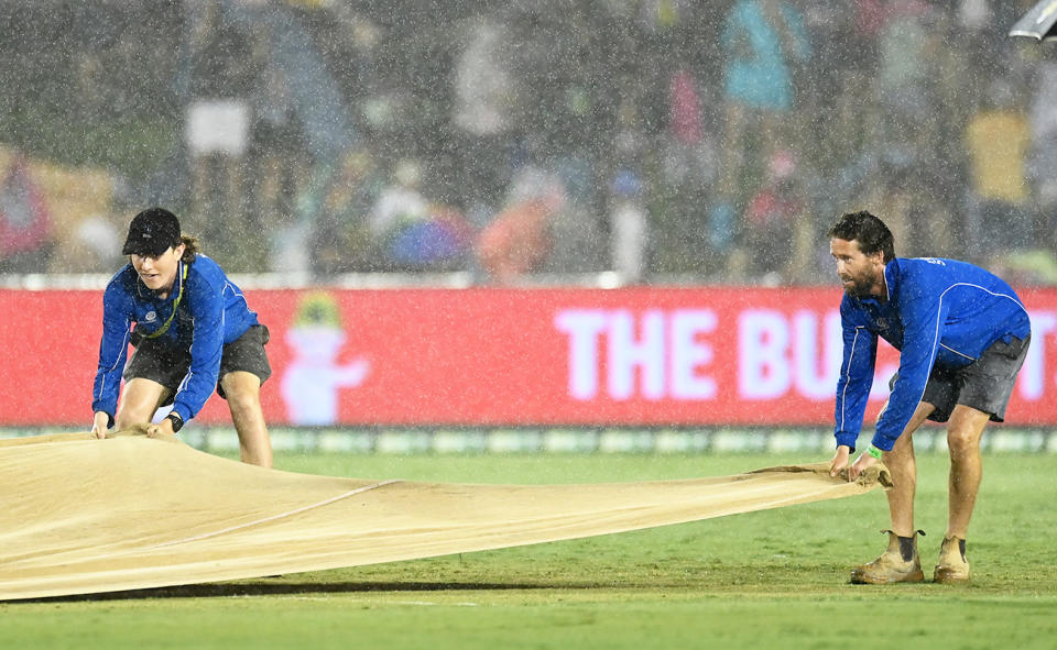 Ground staff, pictured here covering the pitch during the Sydney Sixers' clash with Brisbane Heat in the BBL.