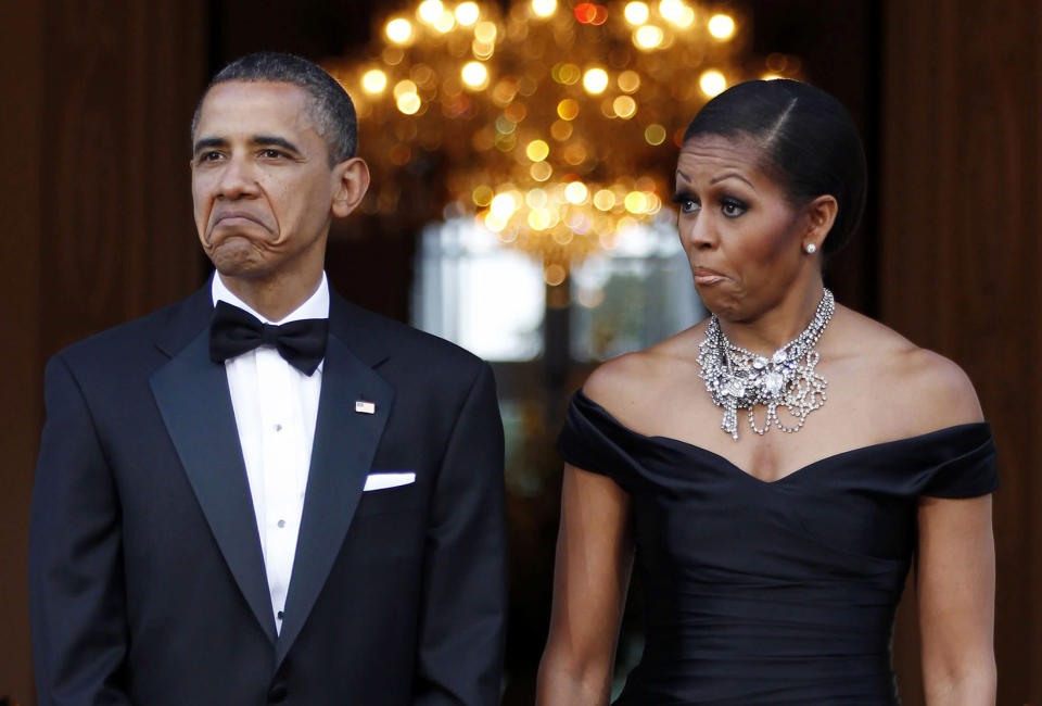 U.S. President Barack Obama (L) and first lady Michelle Obama react as the car carrying Queen Elizabeth and Prince Philip, Duke of Edinburgh, arrives at Winfield House in London, May 25, 2011. REUTERS/Larry Downing (BRITAIN - Tags: POLITICS IMAGES OF THE DAY) FOR BEST QUALITY IMAGE: ALSO SEE GM1E75Q1TOE01