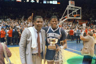 CORRECTS THAT THE GAME WAS AGAINST ST. JOHNS FOR THE BIG EAST CHAMPIONSHIP, NOT AGAINST HOUSTON FOR THE NCAA CHAMPIONSHIP - FILE - In this March 9, 1985, file photo, Georgetown NCAA college basketball head coach John Thompson poses with player Patrick Ewing after Georgetown defeated St. John's in the Big East Championship in New York. John Thompson, the imposing Hall of Famer who turned Georgetown into a “Hoya Paranoia” powerhouse and became the first Black coach to lead a team to the NCAA men’s basketball championship, has died. He was 78 His death was announced in a family statement Monday., Aug. 31, 2020. No details were disclosed.(AP Photo/File)