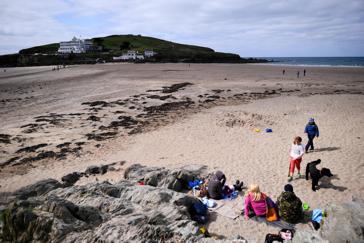 A family sit and play on a beach on the south coast's Bigbury-on-Sea, Britain April 12, 2017. REUTERS/Dylan Martinez