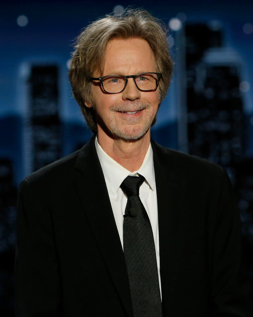 Person in suit with a black tie smiling at the camera