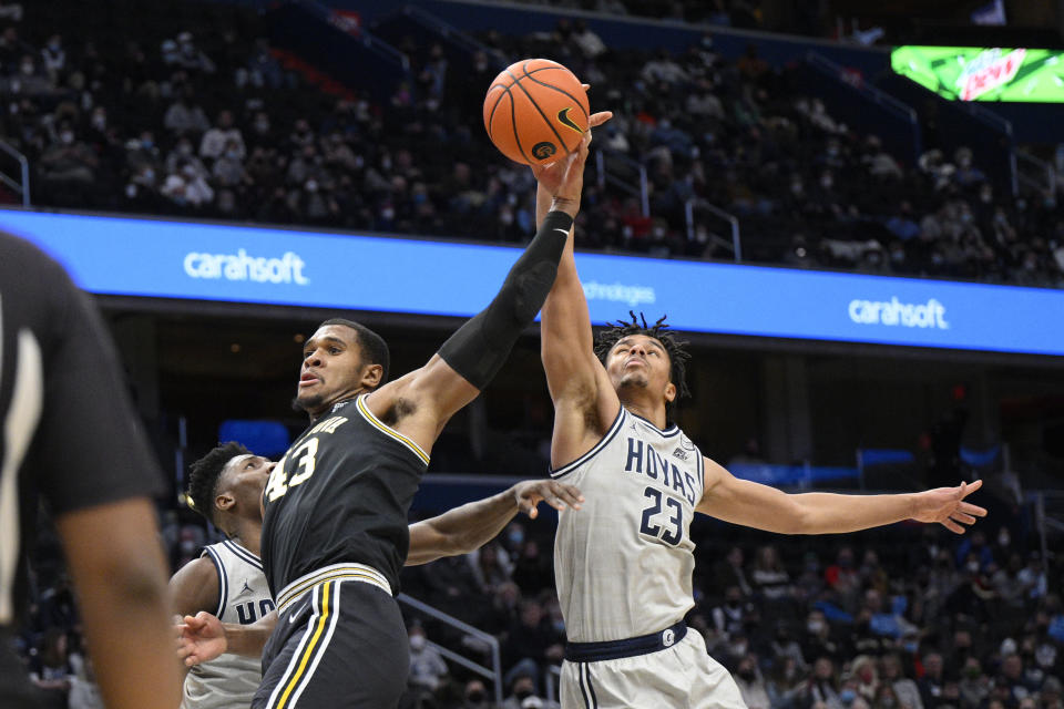 Villanova forward Eric Dixon (43) and Georgetown forward Collin Holloway (23) battle for the ball during the first half of an NCAA college basketball game, Saturday, Jan. 22, 2022, in Washington. (AP Photo/Nick Wass)