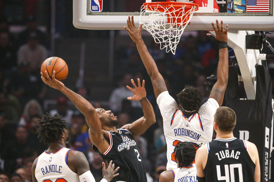 Los Angeles Clippers forward Kawhi Leonard, second from left, shoots under pressure from New York Knicks center Mitchell Robinson, second from right, during the first half of an NBA basketball game Saturday, March 11, 2023, in Los Angeles. (AP Photo/Ringo H.W. Chiu)