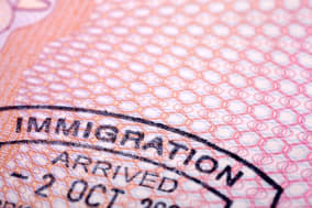 Immigration stamp on a passport page.  Extreme close-up with selective focus. Passport page is gradually blurred with distance.