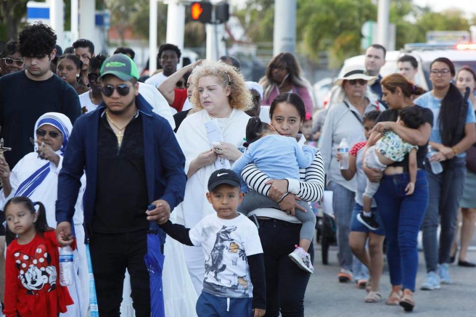 (Center) Yesenia Paniagua walks next to his husband and sons the street of Miami when Archbishop Wenskicelebrates the Liturgy of the Lord’s Passion, the Veneration of the Cross procession at The Cathedral of St. Mary, in Miami on Friday March 29th., 2024.
