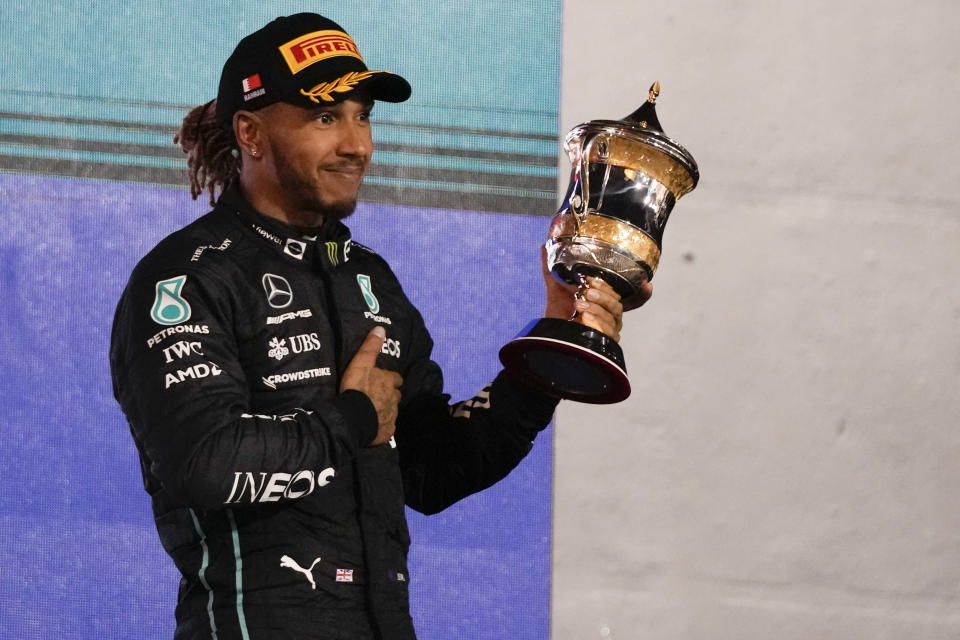 Third placed Mercedes driver Lewis Hamilton of Britain stands on the podium after the Formula One Bahrain Grand Prix it in Sakhir, Bahrain, Sunday, March 20, 2022. (AP Photo/Hassan Ammar)