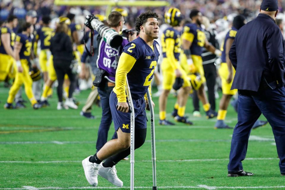 Michigan running back Blake Corum (2) walks off the field with in crutches after the Wolverines lost 51-45 to TCU at the Fiesta Bowl at State Farm Stadium in Glendale, Ariz. on Saturday, Dec. 31, 2022.