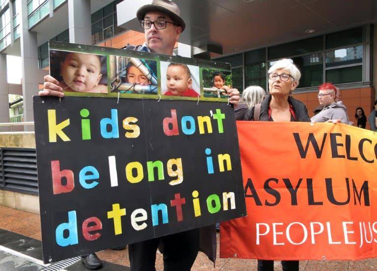 People hold placards at a protest outside an immigration office in Sydney, in February 2016