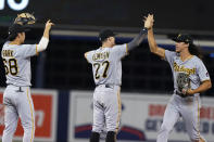 Pittsburgh Pirates shortstop Cole Tucker, right, celebrates with Kevin Newman (27) and Hoy Park (68) at the end of the team's baseball game against the Miami Marlins, Saturday, Sept. 18, 2021, in Miami. The Pirates won 6-3. (AP Photo/Marta Lavandier)