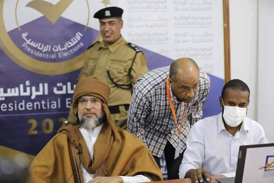 FILE - Seif al-Islam Gadhafi, left, the son and one-time heir apparent of late Libyan dictator Moammar Gadhafi registers his candidacy for the country's presidential elections next month in Sabha, Libya, Sunday, Nov. 14, 2021. After years of looking abroad, mainly to the West, for answers to regional problems, Middle East countries now appear to instead be turning inward, talking to each other about resolving long-running tensions and issues. The closing of ranks also brought a return of realpolitik to the region, a decade after the 2011 Arab Spring that aimed to topple its autocrats. (Libyan High National Elections Commission via AP, File)