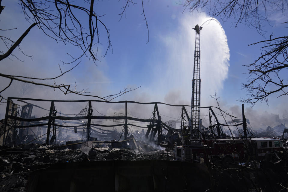 Firefighters pour water on an industrial fire in Richmond, Ind., Thursday, April 13, 2023. Multiple fires that began burning Tuesday afternoon were still burning within about 14 acres of various types of plastics stored inside and outside buildings at the former factory site. (AP Photo/Michael Conroy)