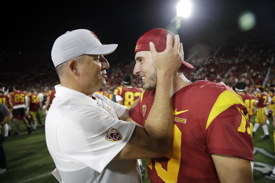 Southern California coach Clay Helton, left, hugs quarterback Matt Fink after the team's 30-23 win over Utah in an NCAA college football game Friday, Sept. 20, 2019, in Los Angeles. (AP Photo/Marcio Jose Sanchez)