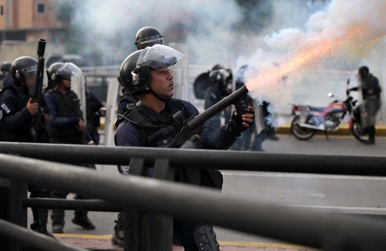 Un policía lanza gases lacrimógenos