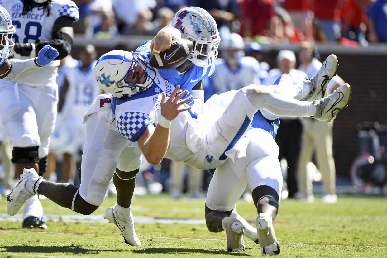 Mississippi safety AJ Finley (21) and linebacker Austin Keys (11) force a fumble from Kentucky quarterback Will Levis (7) in Oxford, Miss., Saturday, Oct. 1, 2022. Mississippi won 22-19. (AP Photo/Thomas Graning)