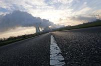 A street is pictured in front of the coal power plant of German utility RWE Power near the western town of Niederaussem in this November 14, 2013 file picture. In recent weeks, the economy that proud German politicians have taken to describing as a "growth locomotive" and "stability anchor" for Europe, has been hit by a barrage of bad news that has surprised even the most ardent Germany sceptics. The big shocker came on August 14, 2014, when the Federal Statistics Office revealed that gross domestic product (GDP) had contracted by 0.2 percent in the second quarter. Picture taken November 14, 2013. TO MATCH STORY GERMANY-ECONOMY/ REUTERS/Ina Fassbender/Files (GERMANY - Tags: BUSINESS EMPLOYMENT ENERGY)