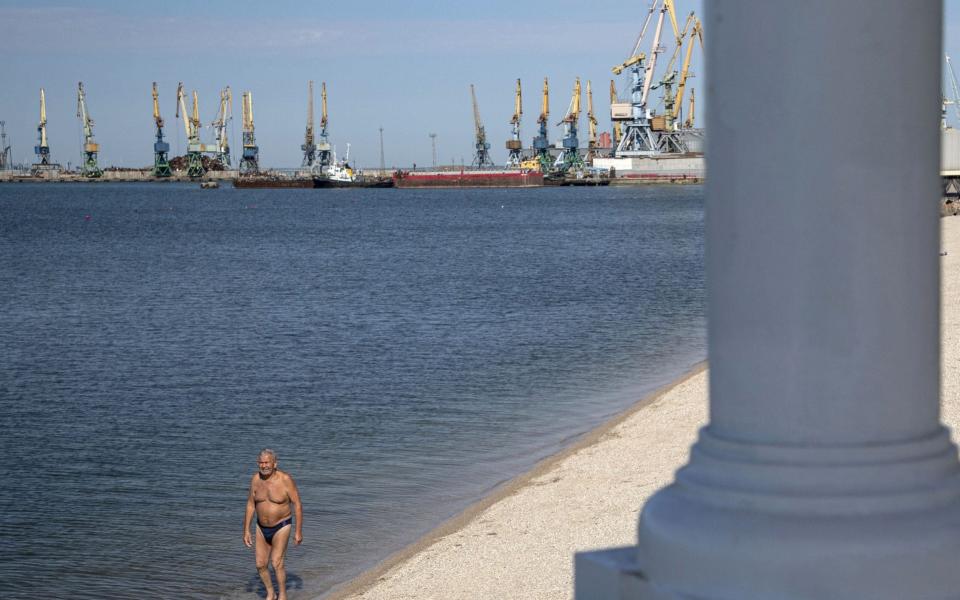 Local people enjoy the sun and Azov sea in front of the cargo sea port in downtown of Berdyansk, Ukraine - SERGEI ILNITSKY/EPA-EFE/Shutterstock/Shutterstock