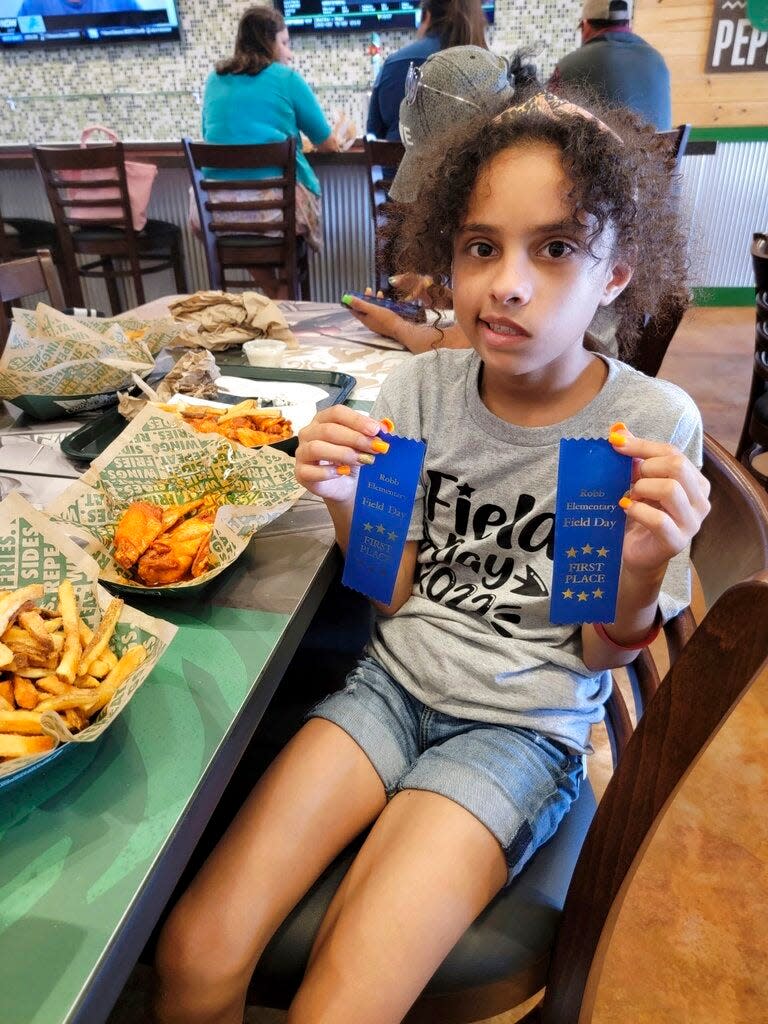 In this image provided by Vincent Salazar, Layla Salazar poses with her first place ribbons from field day at her school, Robb Elementary School. Layla was one of the 19 children and their two teachers who were gunned down behind a barricaded door at Robb Elementary School in Uvalde, Texas.