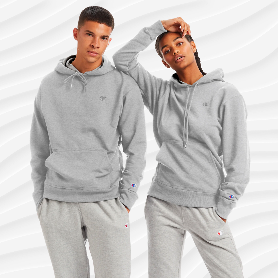 a man and woman wearing the heather grey champion powerblend pullover hoodie