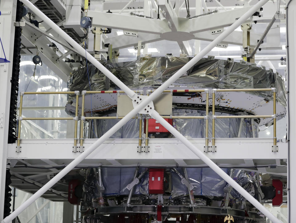 The newly arrived powerhouse, or service module, that will propel NASA's Orion capsule to the moon during a passenger-less test flight planned for 2020 is seen behind a protective structure during a news conference with U.S. and European space leaders at the Kennedy Space Center Friday, Nov. 16, 2018, in Cape Canaveral, Fla. (AP Photo/John Raoux)