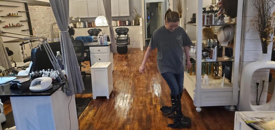 Suzzanne Sanders cleans the floor Tuesday in Indulgence Salon and Spa in downtown Prattville. The business is at the intersection of West Main and Court streets in downtown Prattville and was flooded by the heavy rains. It remained open.