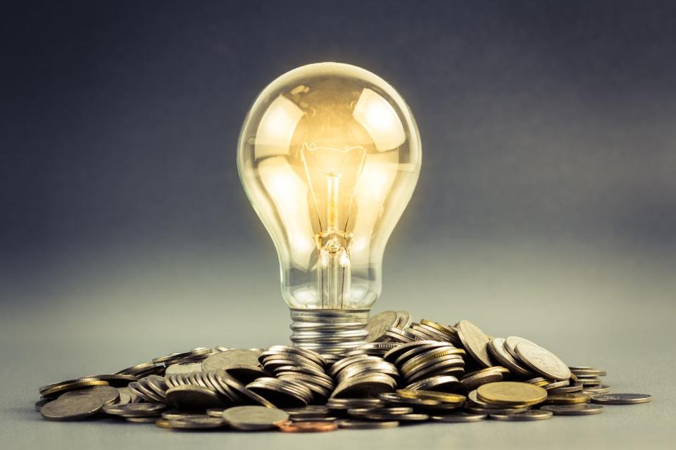 A light bulb sitting on a pile of coins