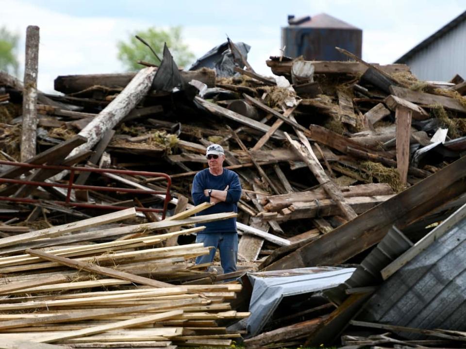 George Moffatt stands among the wreckage at his friend’s farm in the community of Cheney in Clarence-Rockland, Ont., on Monday. (Justin Tang/The Canadian Press - image credit)