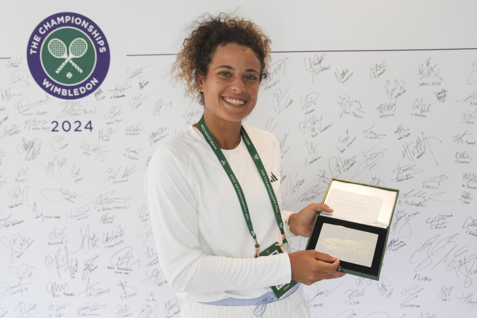 Mayar Sheif of Egypt holds the sterling silver plaques players receive at Wimbledon in London, Sunday, June 30, 2024.In a relatively well-kept secret — even some athletes were completely unaware when asked about the keepsakes by The Associated Press during the tournament that wraps up next weekend — the All England Club distributes the mementos to all 256 players in the women's and men's singles brackets, as well as those in doubles and wheelchair events. (AP Photo/Mosa'ab Elshamy)