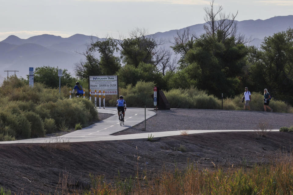 Cyclists move through the 2,900 acre Clark County Wetland Park on Friday, Aug. 26, 2022, in Clark County, Nev. The Las Vegas Wash, that runs through the park, is a crucial part of how Nevada has managed to keep its net Colorado River use below its allocation, despite booming population growth and two decades of persistent drought, worsened by a changing climate. (Jeff Scheid/The Nevada Independent via AP)