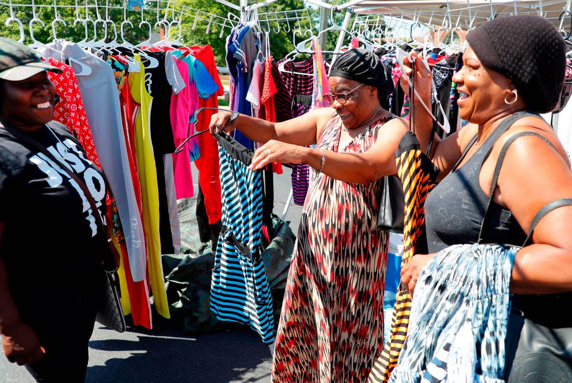 Diane Johnson, center, and Pamela Ingram, right, shop as vendor Redina Thomas, left, helps them in Benson, N.C. Friday, June 18, 2021. Thomas’ shop was part of the 301 Endless Yard Sale, a yearly yard sale the has vendors setting up along the side of U.S. Hwy. 301 in five counties.