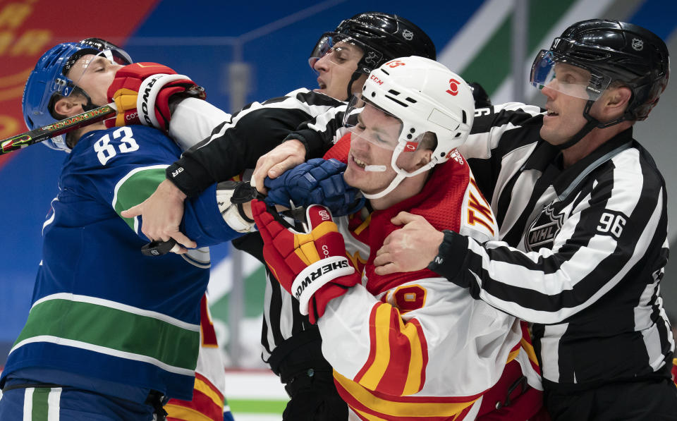 Vancouver Canucks center Jay Beagle (83) tussles with Calgary Flames left wing Matthew Tkachuk (19) during the second period of an NHL hockey game Thursday, Feb. 11, 2021, in Vancouver, British Columbia. (Jonathan Hayward/The Canadian Press via AP)