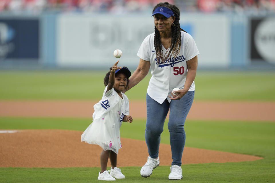 Kynlee Betts, left, daughter of Los Angeles Dodgers right fielder Mookie Betts, throws out the first pitch with her grandmother, Diana Benedict, before a baseball game against the Minnesota Twins in Los Angeles, Monday, May 15, 2023. (AP Photo/Ashley Landis)