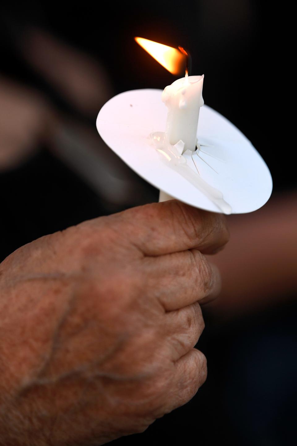 Honoring the three teens who died, a mourner holds a candle during a memorial service in Baird May 7.