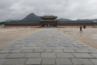 A visitor wearing a face masks to help protect against the spread of the coronavirus walks along on a nearly empty the Gyeongbok Palace, the main royal palace during the Joseon Dynasty, in Seoul, South Korea, Thursday, Aug. 27, 2020. South Korea reported more than 400 new cases of the coronavirus, its highest single-day total in months, making lockdown-like restrictions look inevitable as transmissions slip out of control. (AP Photo/Ahn Young-joon)