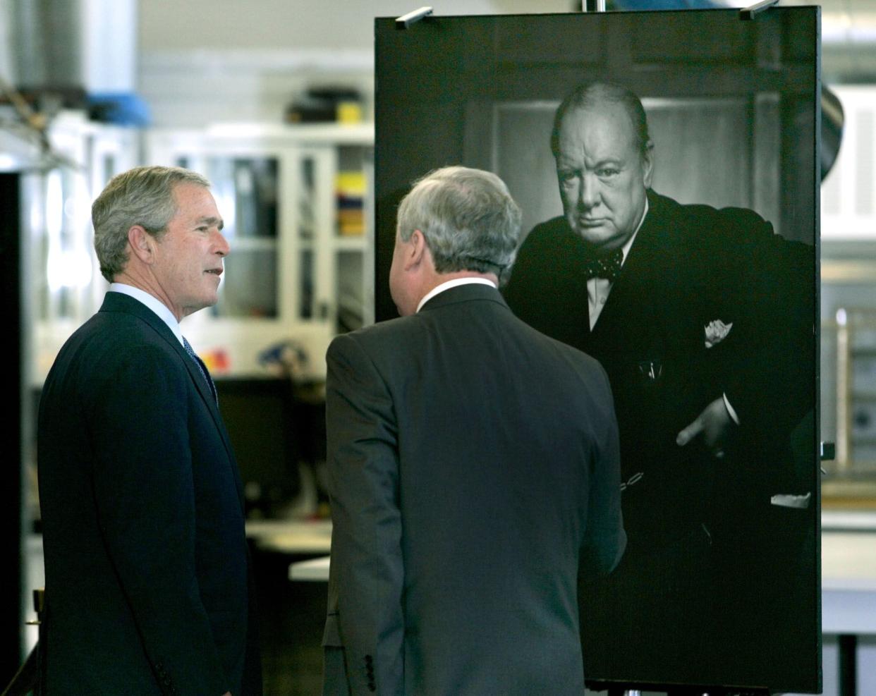 U.S. President George W. Bush, left, stops by a portrait of former British Prime Minister Winston Churchill by Canadian photographer Yousuf Karsh during a tour of  the National Archives Preservation Center in Ottawa, Canada, Tuesday, Nov. 30, 2004.