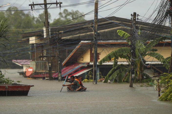 Residents paddle through floodwaters in Ubon Ratchathani province, northeastern Thailand, Monday, Oct. 3, 2022. Heavy rainfall in northern, northeastern and central Thailand on Monday fueled severe flooding, as some areas were further threatened as the authorities had to order pressure on filled to capacity dams eased by releasing water into already overflowing rivers. (AP Photo/Nava Sangthong)