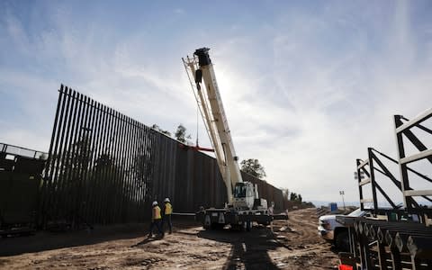 Construction continues on a new, taller version of the border structure in Calexico, Calif - Credit: AP