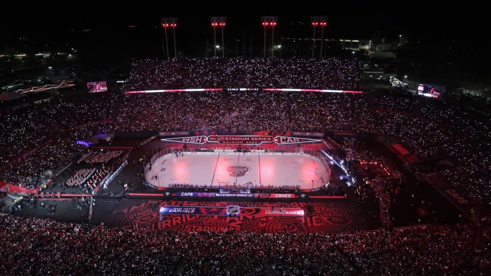 FILE - Fans hold lighted cellphones as the lights are dimmed before an NHL hockey Stadium Series game between the Washington Capitals and the Carolina Hurricanes on Feb. 18, 2023, in Raleigh, N.C. Carolina will take on the Florida Panthers in the Eastern Conference Final, with Game 1 on Thursday, May 18. (AP Photo/Chris Seward, File)