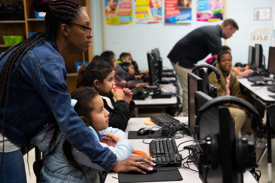 Demetria Brown helps Rubi Rosa Mejia during fourth grade computer class at Tom Joy Elementary School in Nashville, Tenn., Monday, Nov. 28, 2022.