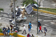 <p>People walk past a street barricade that includes a mattress with the words “Maduro son of a bitch” after clashes broke out while the Constituent Assembly election was being carried out in Caracas, Venezuela, July 30, 2017. (Christian Veron/Reuters) </p>