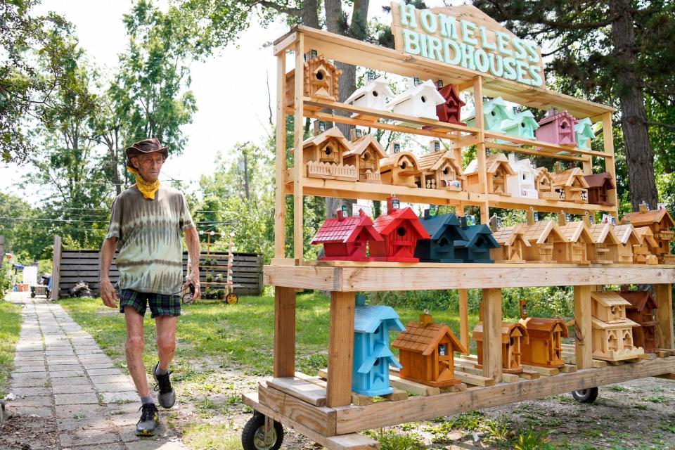 Tom Esshaki walks towards his birdhouse display in his driveway in Southfield on Tuesday, July 11, 2023. 