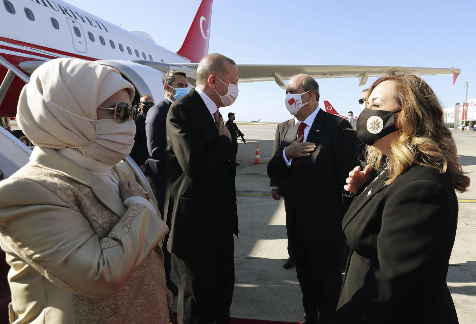 Turkey's President Recep Tayyip Erdogan, left, his wife Emine Erdogan, left, Ersin Tatar, second right, and his wife Sibel Tatar, greet each other during a welcome ceremony at Ercan Airport, in Nicosia, Northern Cyprus, Sunday, Nov. 15, 2020. Erdogan will attend ceremonies celebrating the 37th foundation anniversary of the Northern Turkish Cypriot Republic. (Turkish Presidency via AP, Pool)
