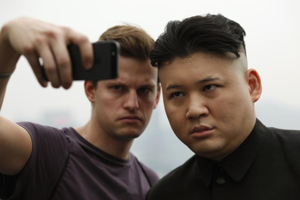 Howard poses as a Kim Jong-un lookalike with a journalist on a street at Hong Kong's Tsim Sha Tsui shopping district