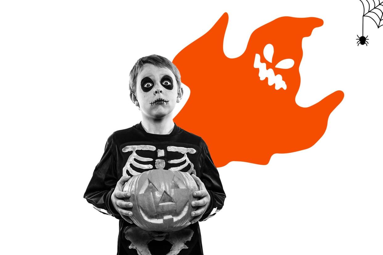 Young boy in a skeleton Halloween costume. A ghost floats above him.