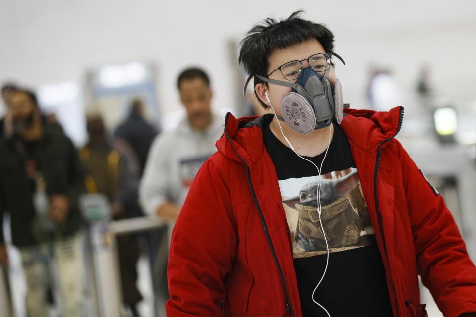 A commuter wears a face mask in the New York City transit system, Monday, March 9, 2020, in New York. New York continued grappling Monday with the new coronavirus, as case numbers, school closings and other consequences grew. (AP Photo/John Minchillo)