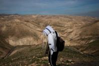 A Jewish shepherd wears a prayer shawl as he stands in the landscape in the Israeli settlement of Mitzpe Yericho in the Jordan Valley in the Israeli-occupied West Bank