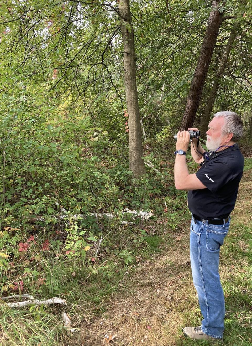 Jerry McWilliams searches for birds while walking the trails at Presque Isle State Park on Oct. 12. McWilliams, 70, has bird watched on the peninsula for nearly 50 years.