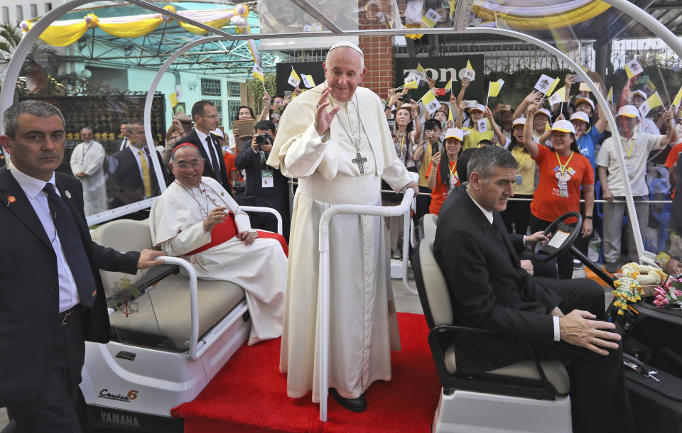 Pope Francis waves to a crowd standing hours to greet him as he arrives at the Saint Louis hospital in Bangkok, Thailand, Thursday, Nov. 21, 2019. Pope Francis called for migrants to be welcomed and for women and children to be protected from exploitation, abuse and enslavement as he began a busy two days of activities in Thailand on Thursday. (AP Photo/Manish Swarup)